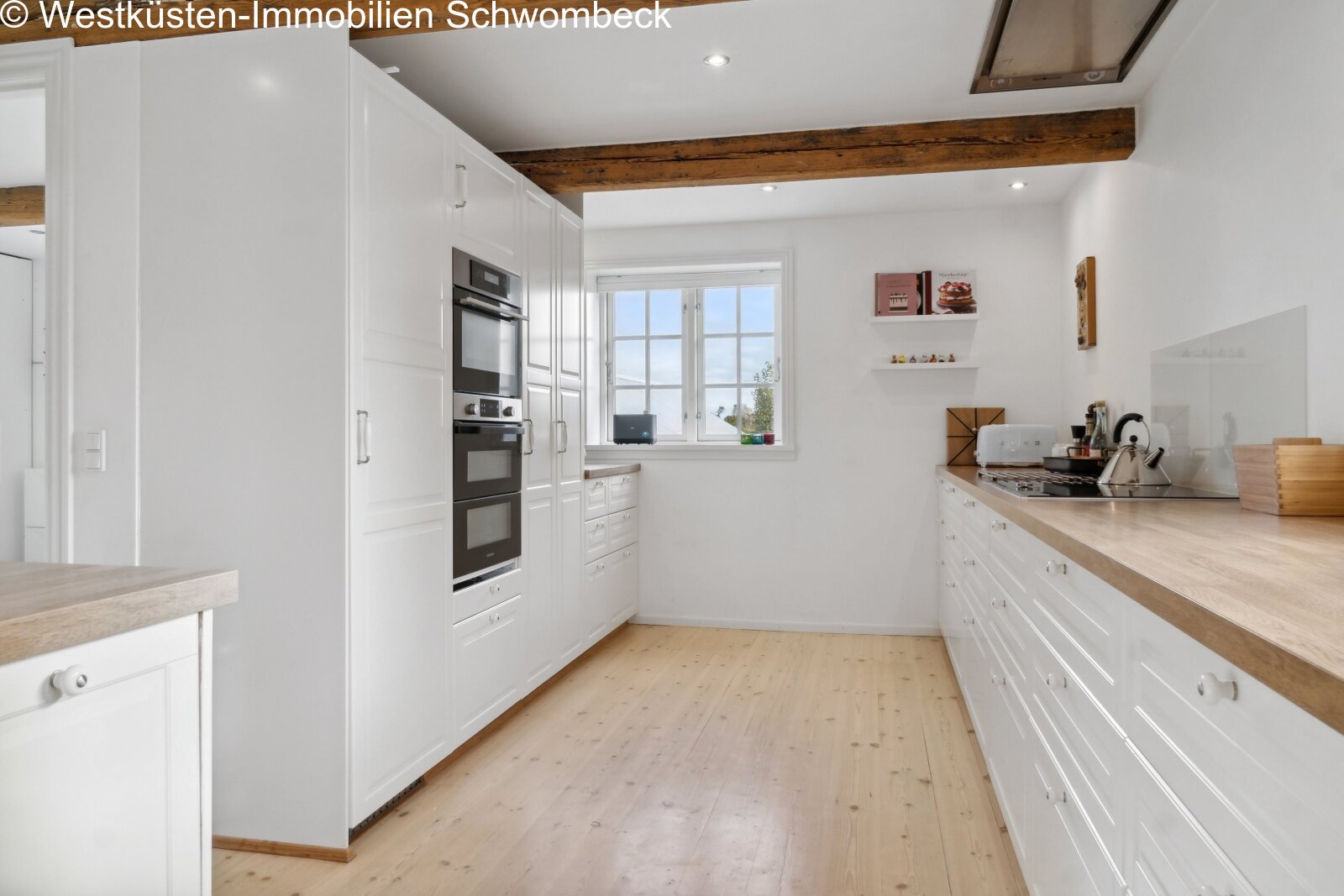 Moderne Küche mit Doppelbackofen und Balkendecke