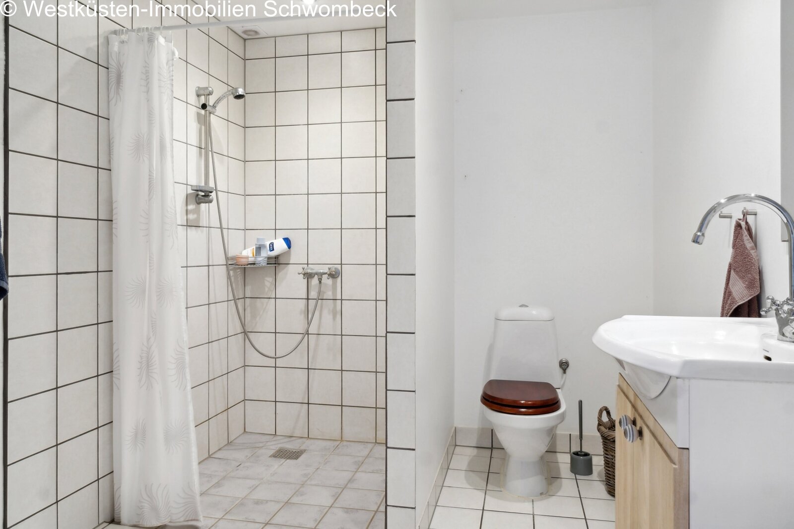 Modernes Badezimmer mit ebenerdiger Dusche und praktischer Ausstattung