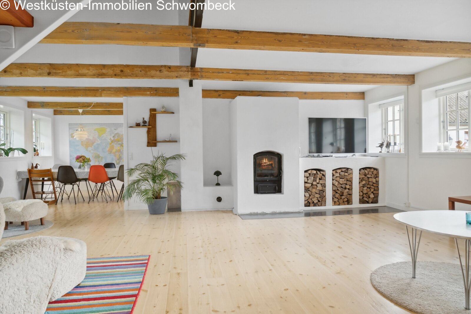 Offener Wohnbereich mit Kaminofen und charaktervollen Holzbalken