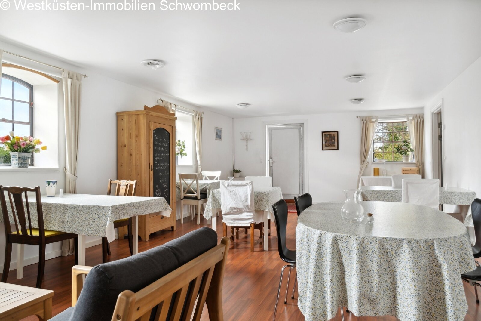 Helles Speisezimmer mit vielfältigen Sitzbereichen und großflächigen Fenstern