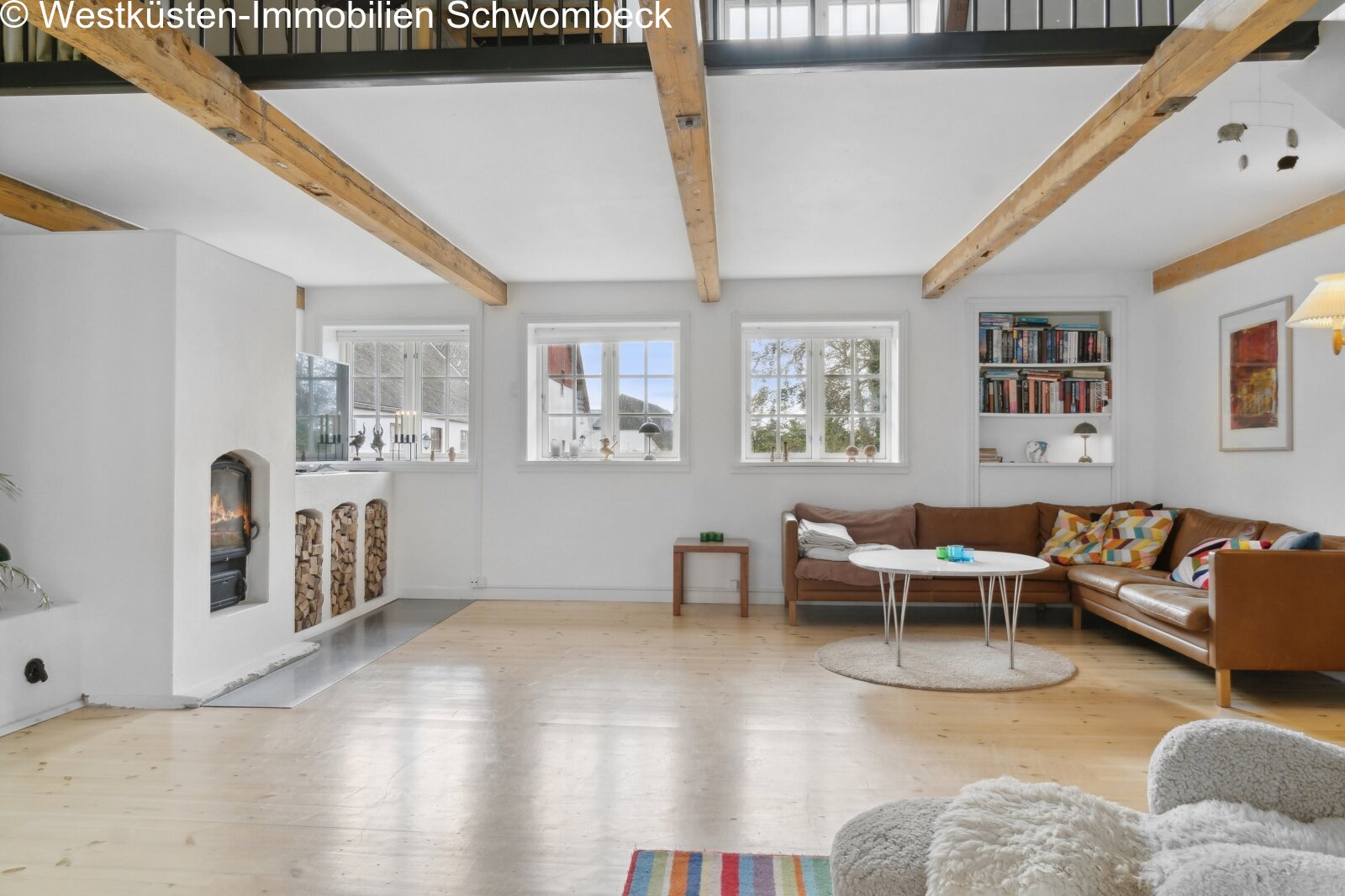 Lichterfluteter Wohnbereich mit Kaminofen und charaktervollen Holzbalken