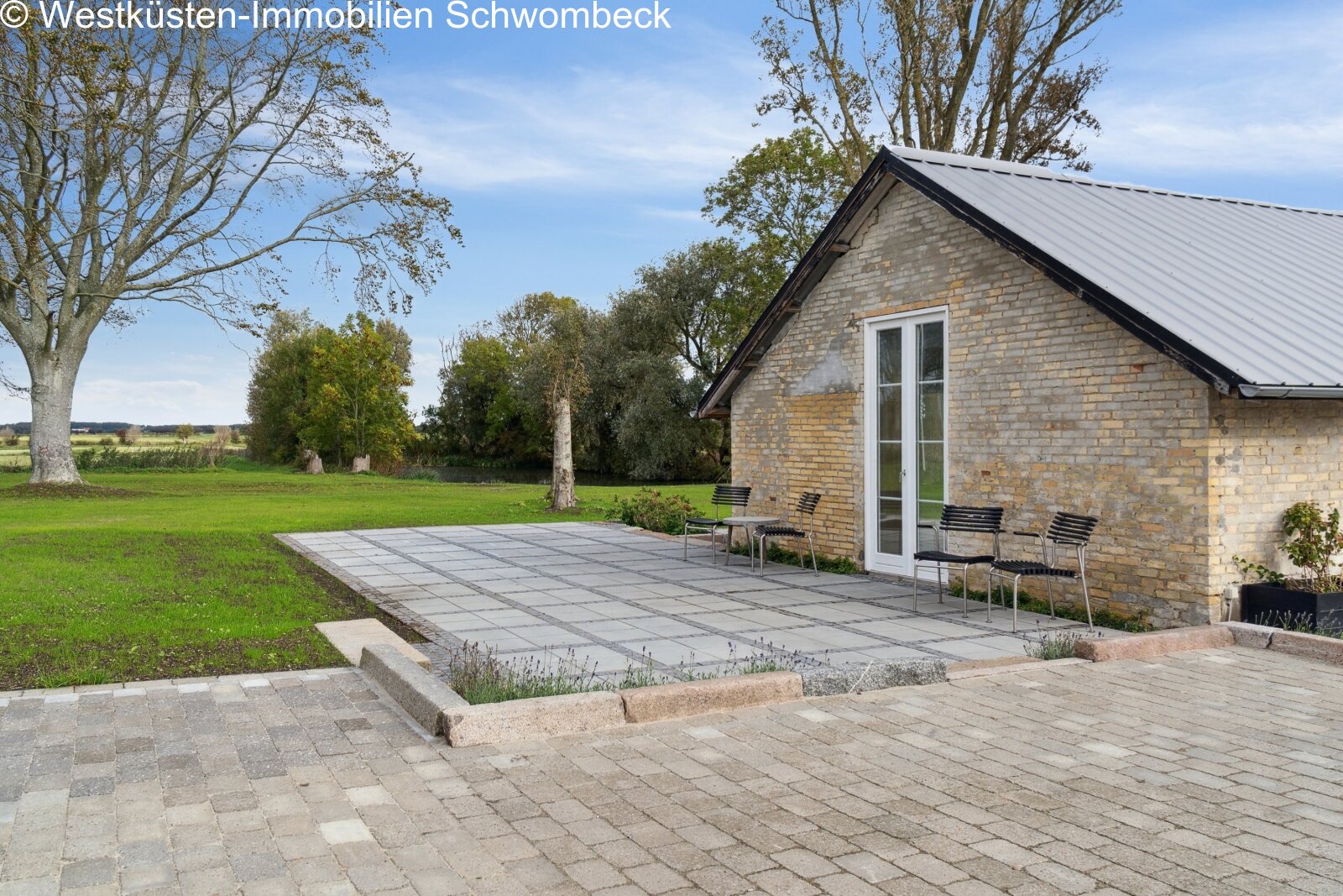 Terrassenanlage mit hochwertiger Natursteinpflasterung und direktem Landschaftszugang