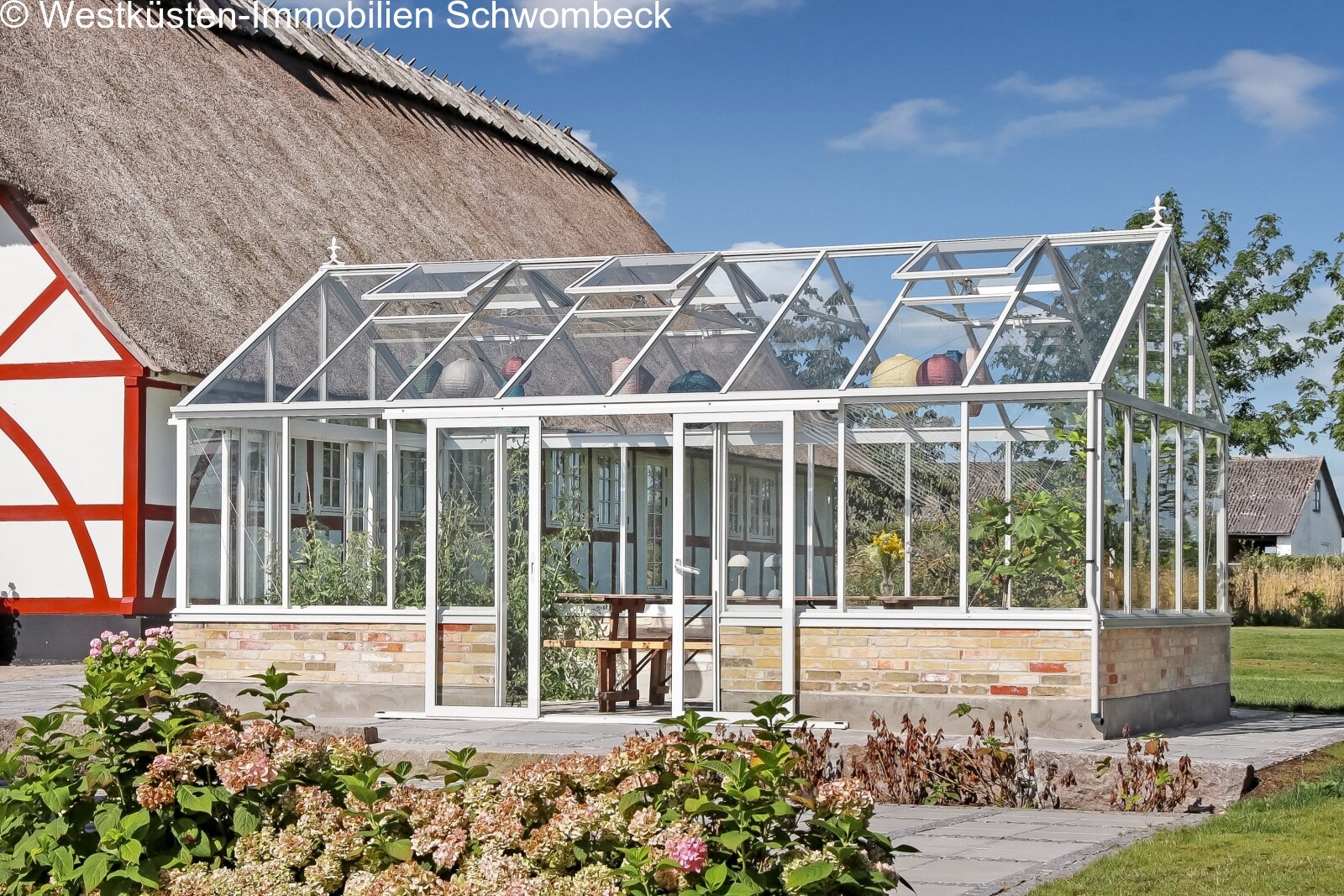 Lichterflutete Wintergarten-Erweiterung mit Aluminium-Rahmenkonstruktion und Natursteinterrasse