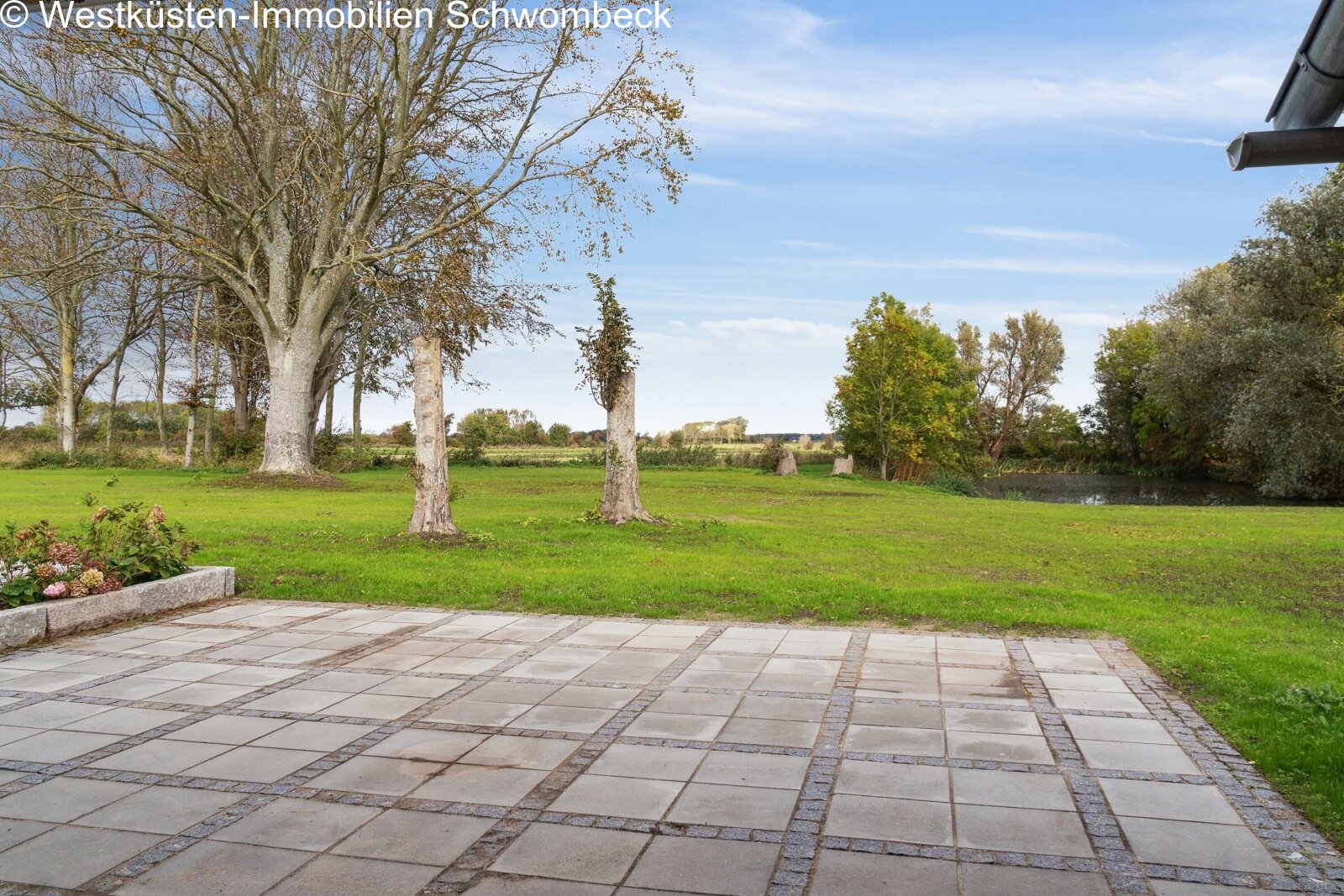 Terrassenanlage mit hochwertiger Natursteinpflasterung und freiem Landschaftszugang