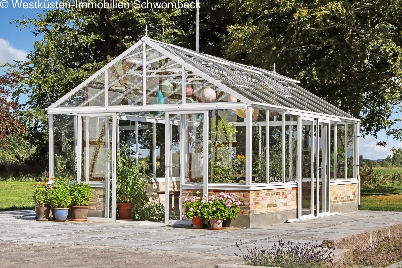Lichterflutetes Gewächshaus mit Aluminium-Rahmenkonstruktion und Natursteinterrasse