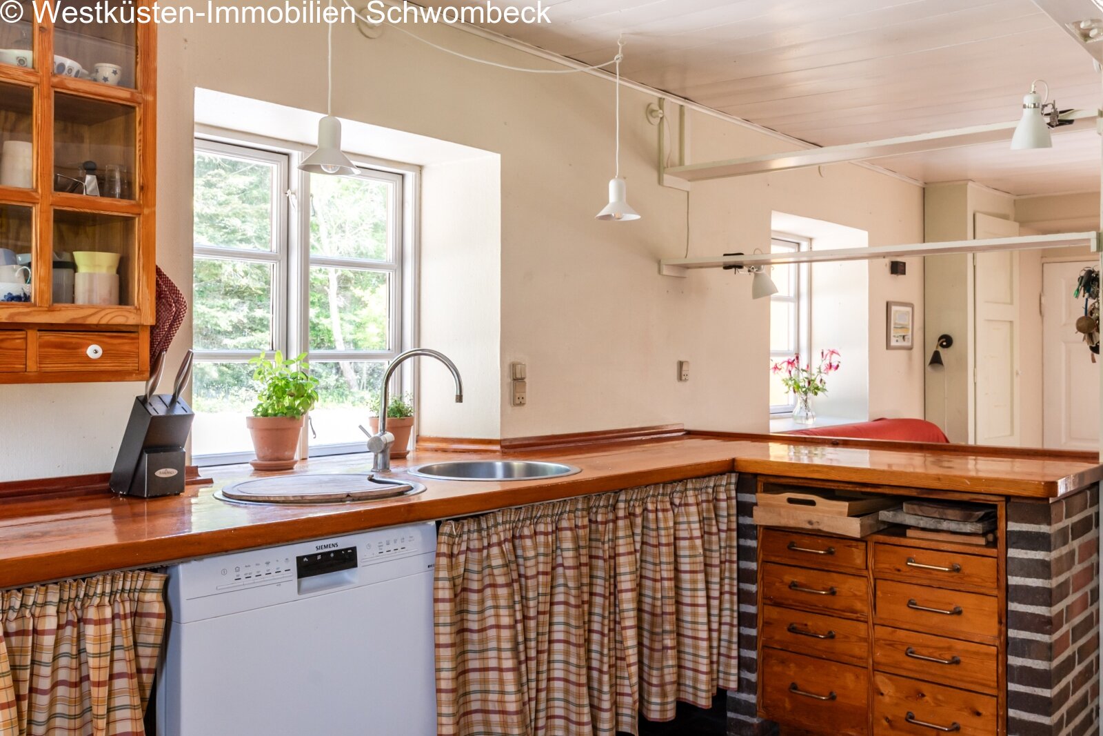 Küche mit Tresen und großflächigen Fenstern zum Garten
