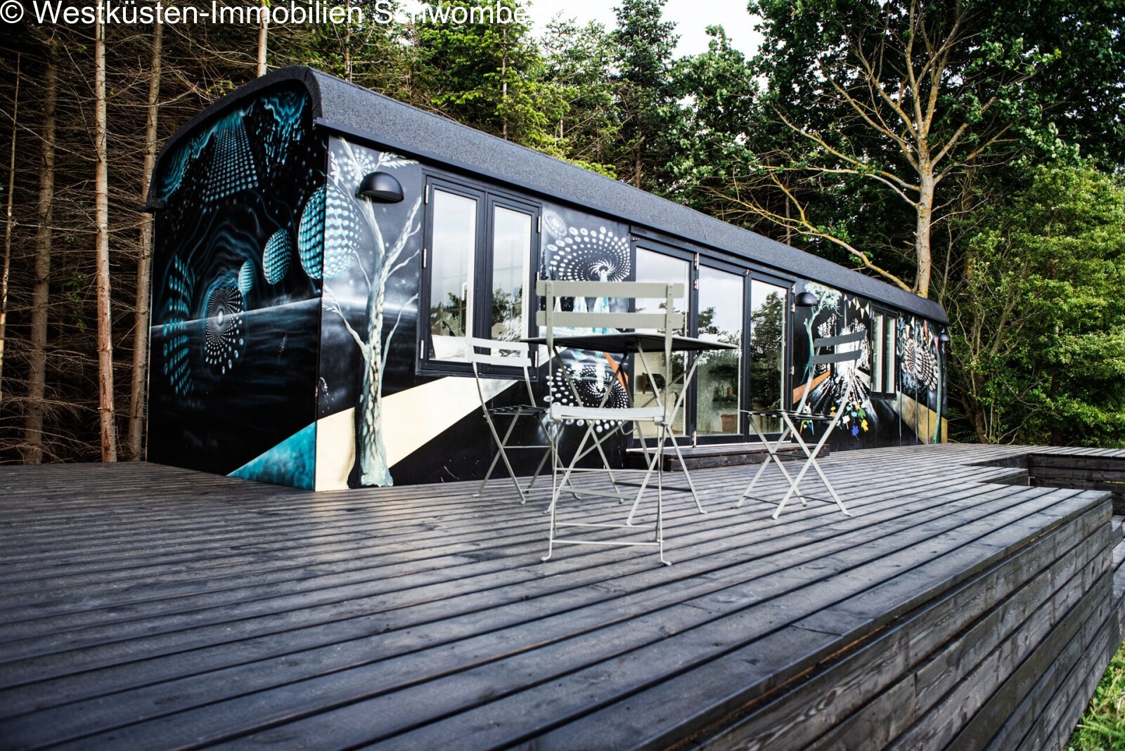 Zirkuswagen als Gästehaus, mit raumhohen Verglasungen und überdachter Terrasse