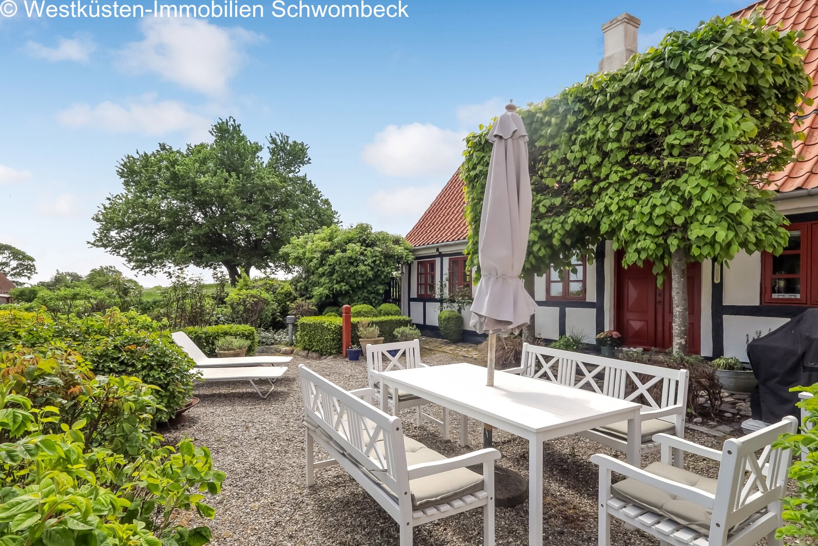Verwöhnter Außenbereich mit gepflastertem Hof und schattenspendender Pergola Verwöhnter Außenbereich mit gepflastertem Hof und schattenspendender Pergola