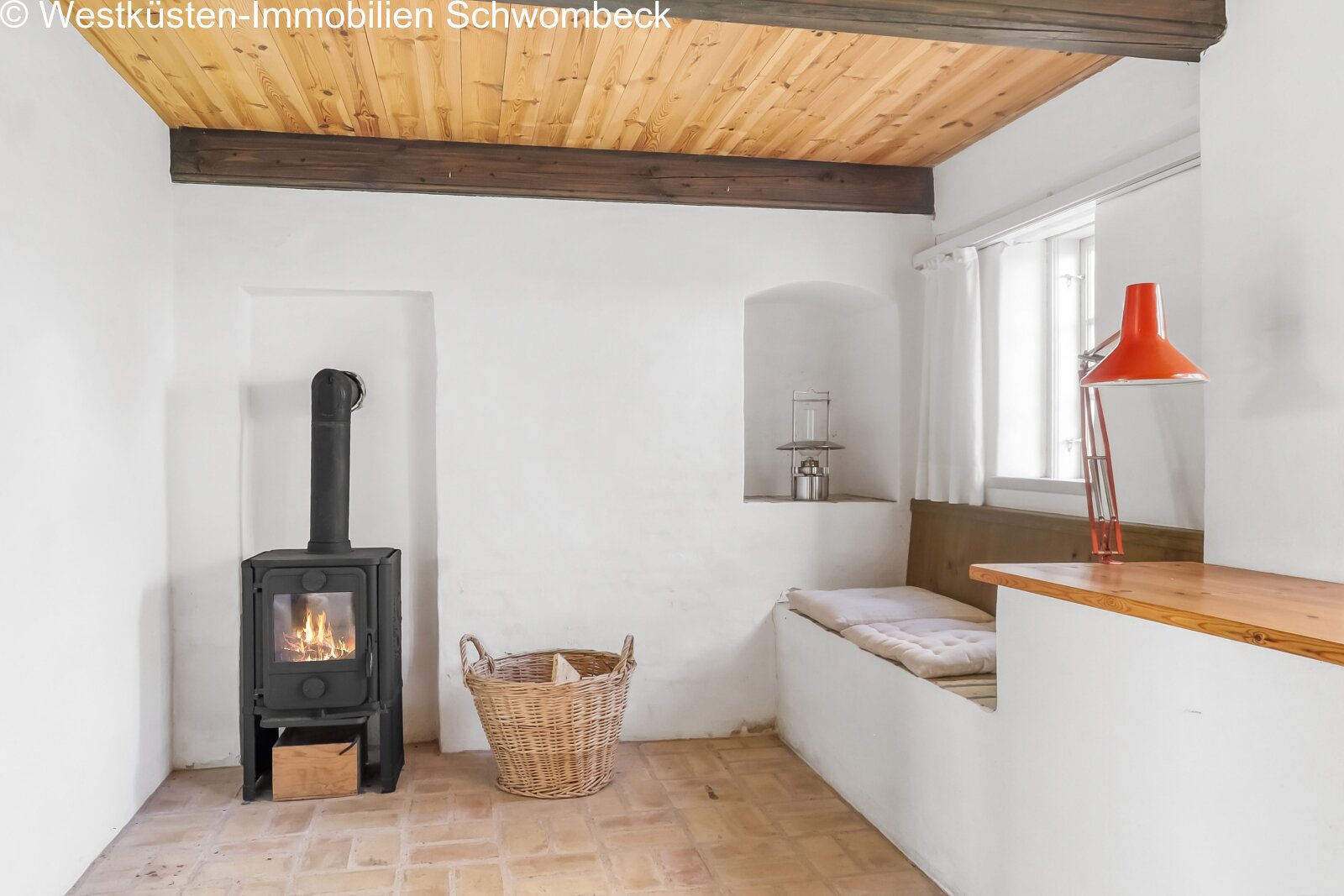 Gemütlicher Wohnbereich mit Kaminofen und rustikaler Holzbalkendecke Gemütlicher Wohnbereich mit Kaminofen und rustikaler Holzbalkendecke