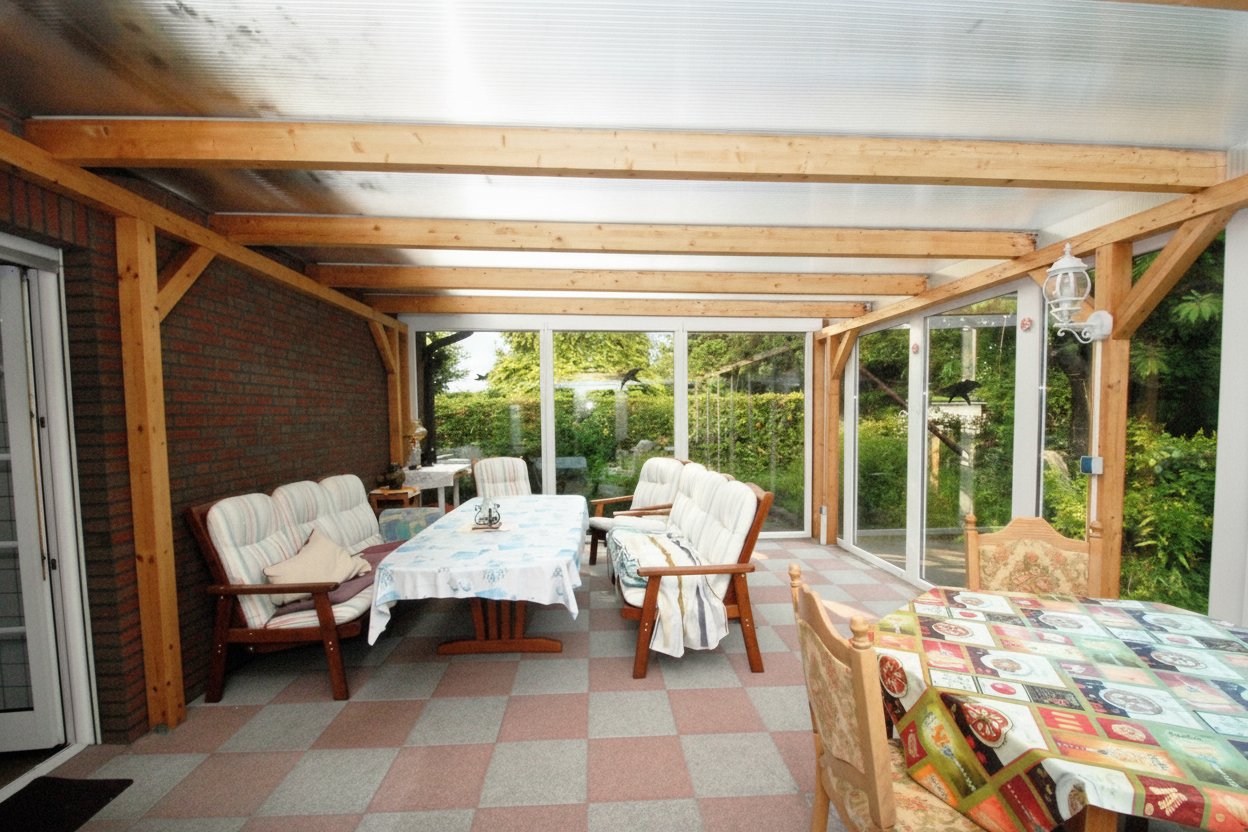 Wintergarten mit massiver Holzkonstruktion und rundum verglaster Gartenanbindung Wintergarten mit massiver Holzkonstruktion und rundum verglaster Gartenanbindung