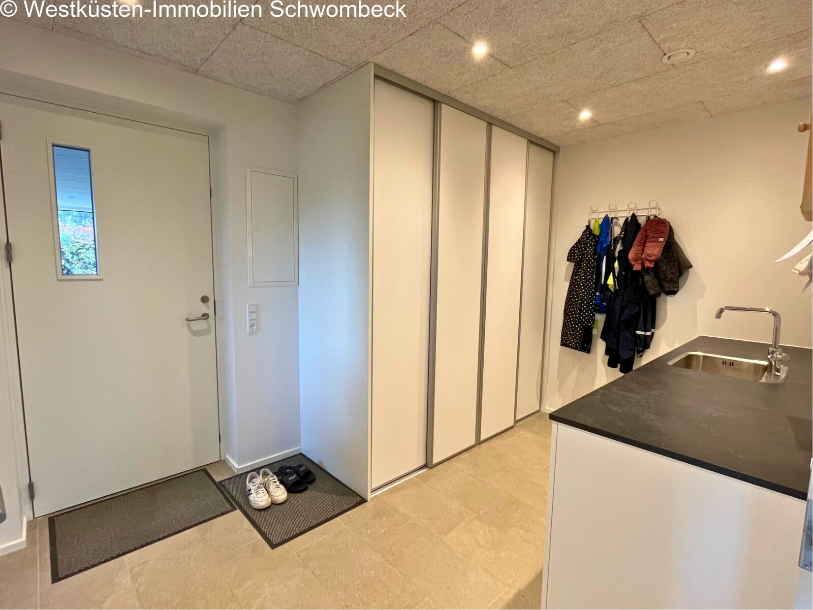 Funktionaler Eingangsbereich mit maßgeschneiderten Schranklösungen und praktischer Garderobe