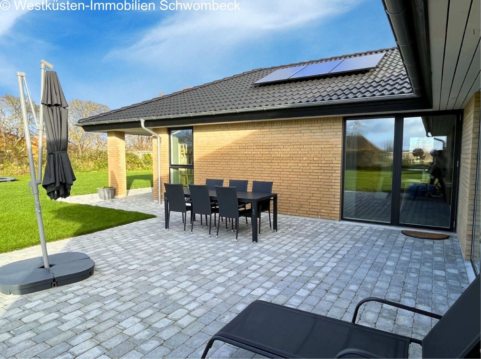 Terrassenbereich mit hochwertiger Pflasterung und direkter Gartenanbindung