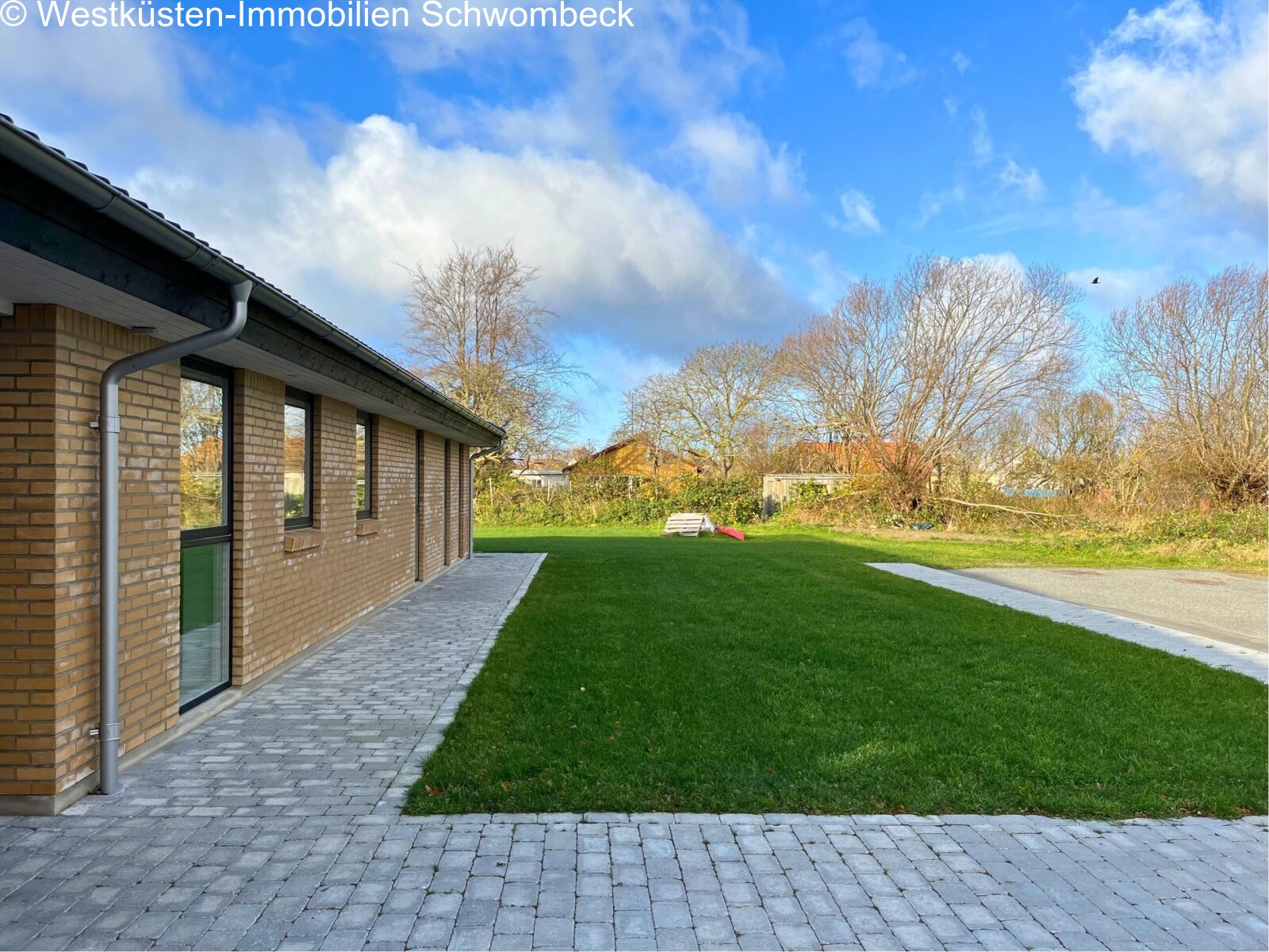 Terrassenanlage mit gepflastertem Zugang und unverbaubarem Gartenblick