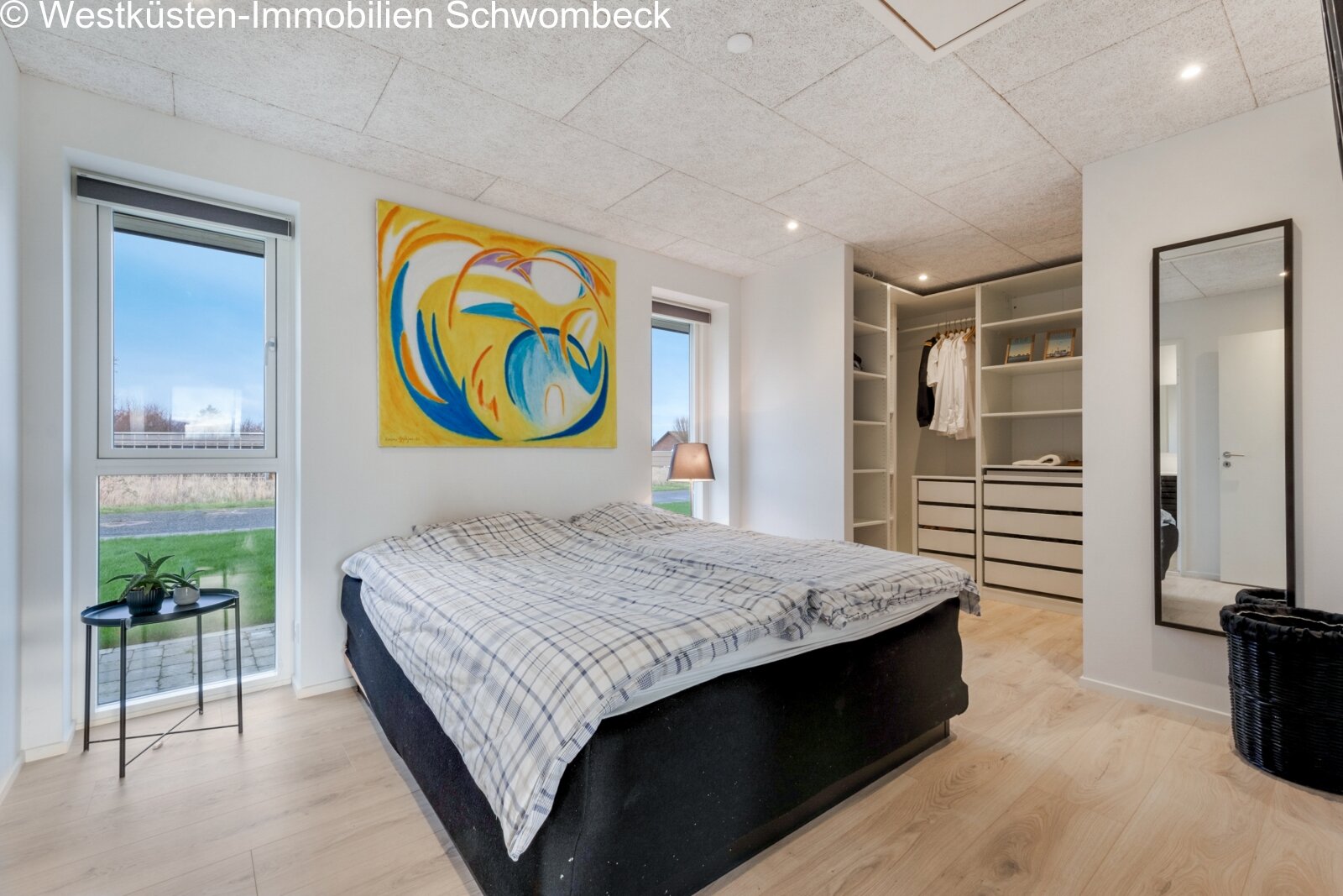 Komfortables Schlafzimmer mit begehbarem Kleiderschrank und Panoramafenster