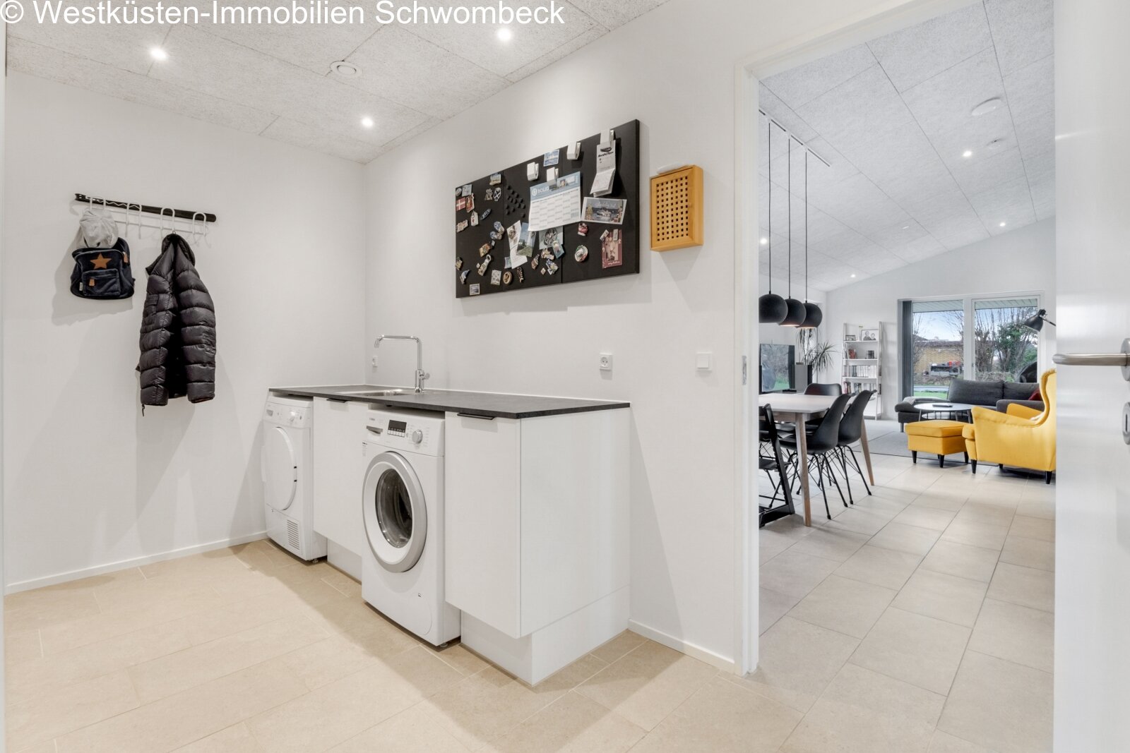 Praktische Waschküche mit integriertem Trockner und ergonomischer Arbeitsfläche