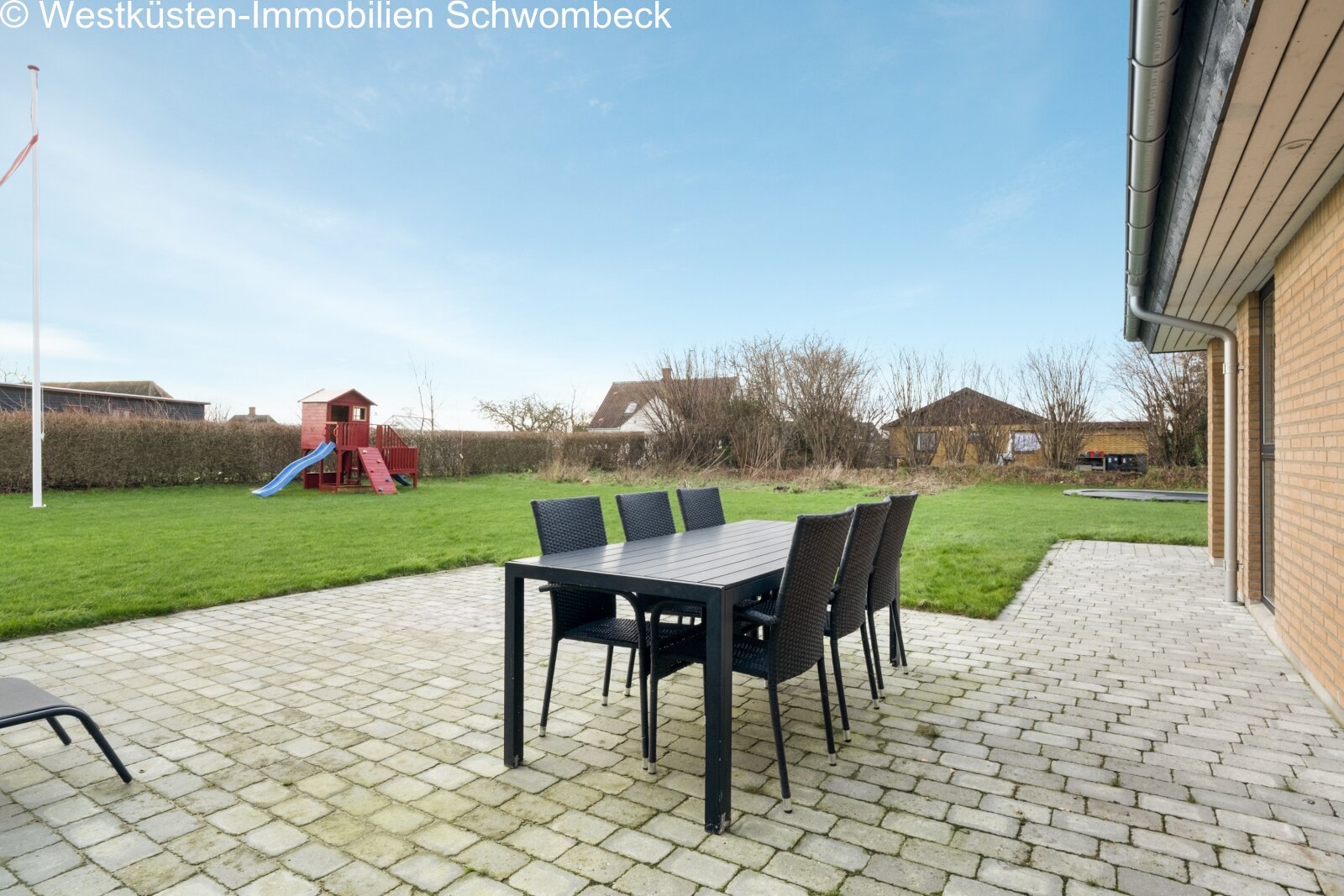Terrassenbereich mit hochwertiger Natursteinpflasterung und freiem Gartenblick
