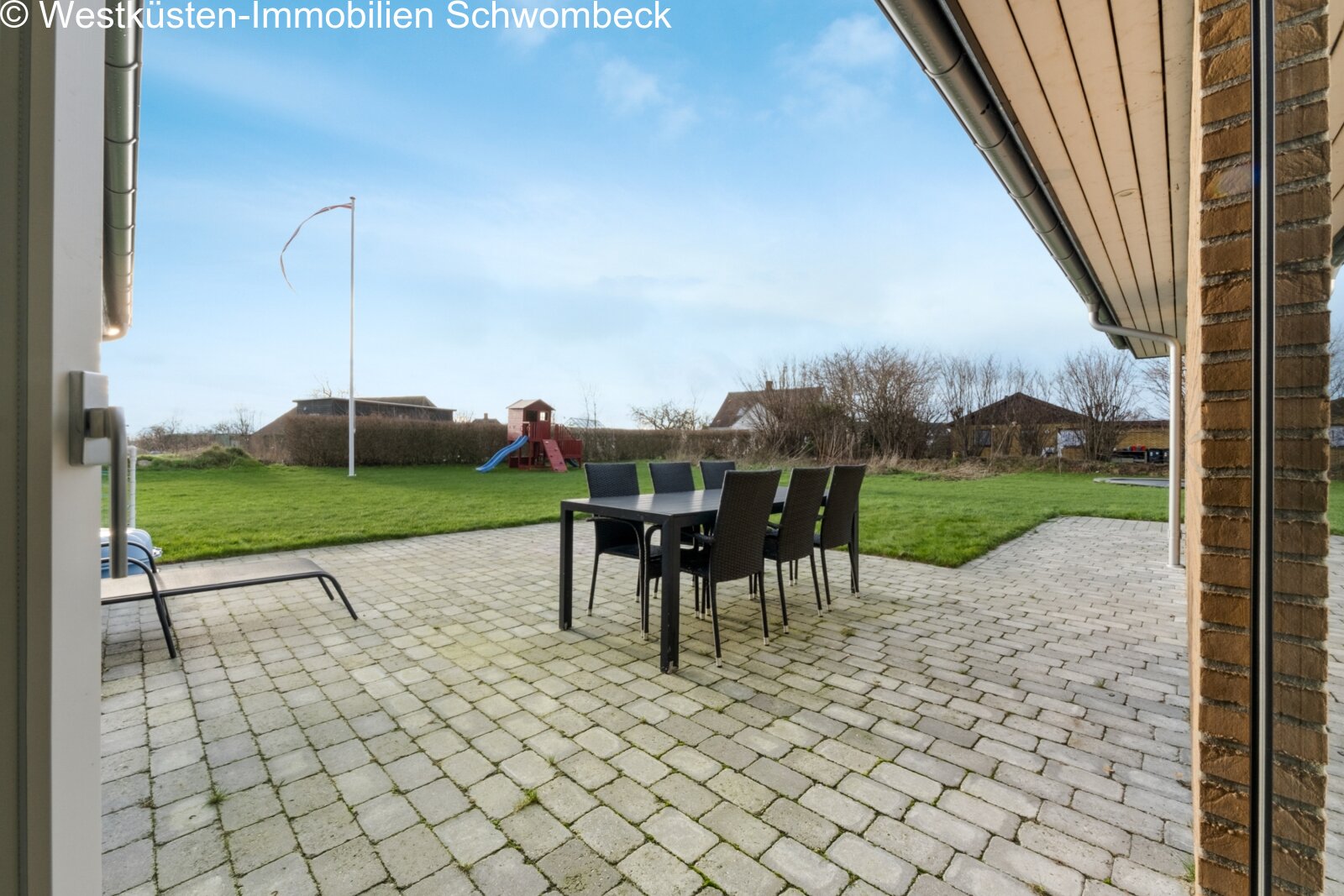 Terrassenbereich mit hochwertiger Pflasterung und unverbaubarem Blick ins Grüne