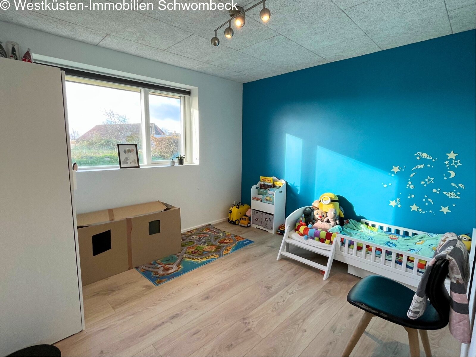 Helles Kinderzimmer mit Panoramafenster und praktischen Stauraumlösungen
