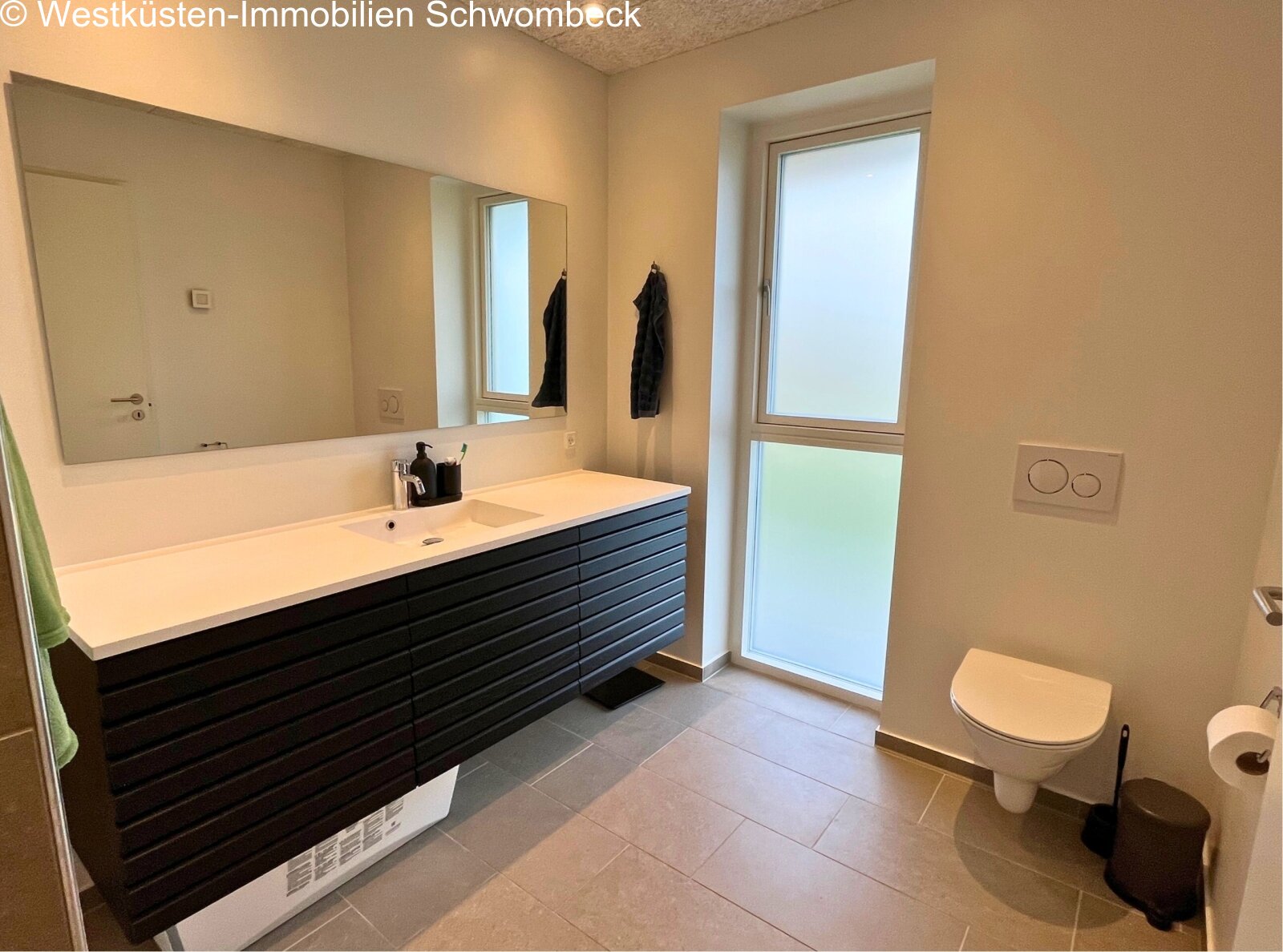 Modernes Badezimmer mit doppelter Waschtischanlage und bodentiefen Glaselementen