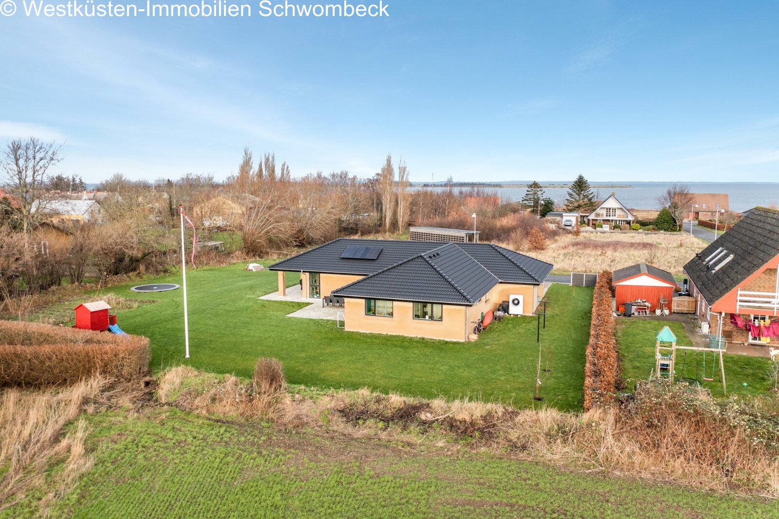 Moderne Bungalow-Architektur mit Solaranlage und parkähnlichem Grundstück mit Seepanorama