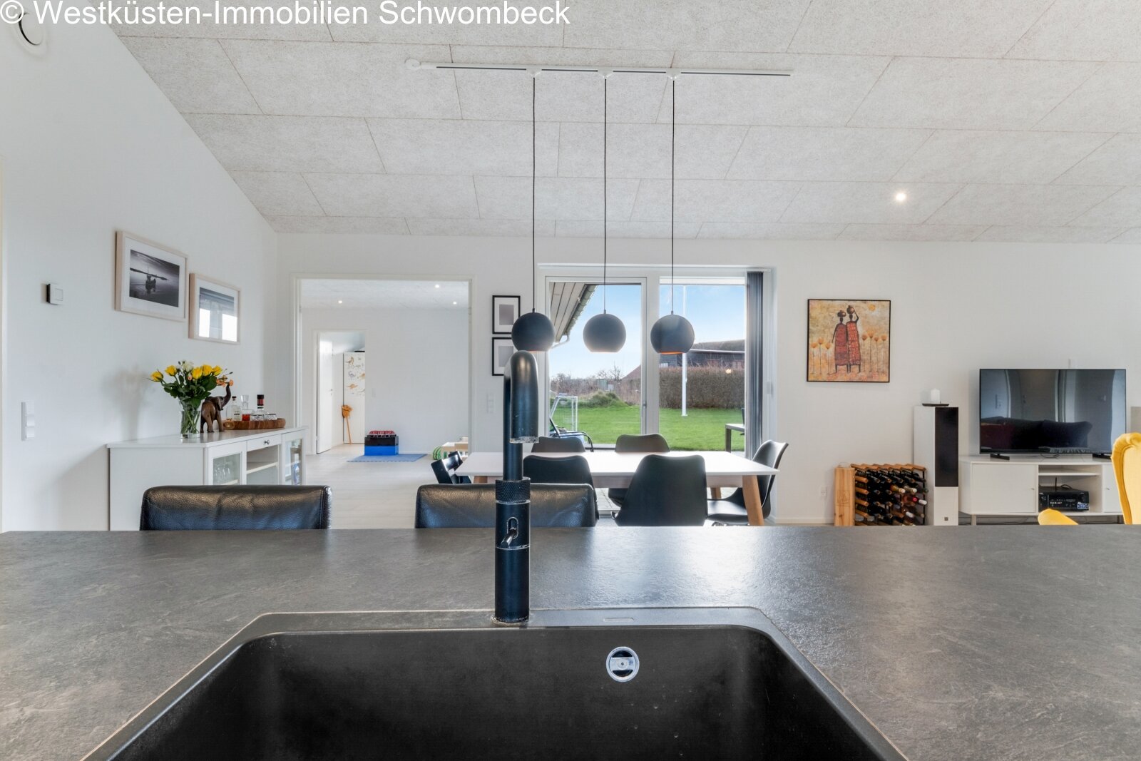 Offene Wohnlandschaft mit fließenden Raumübergängen und Panoramablick ins Grüne
