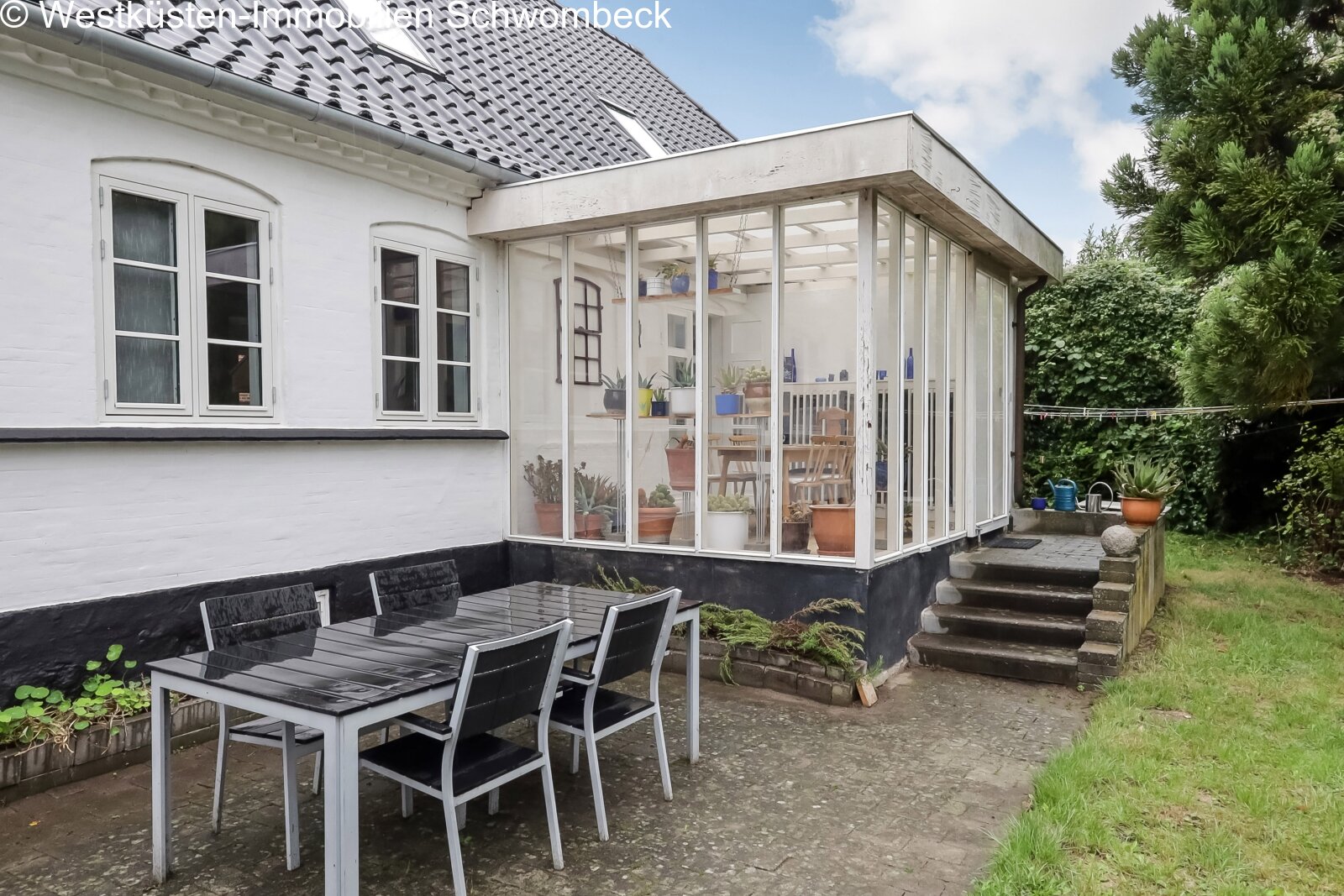 Wintergarten mit rahmenloser Verglasung und fließendem Übergang zum Garten Wintergarten mit rahmenloser Verglasung und fließendem Übergang zum Garten